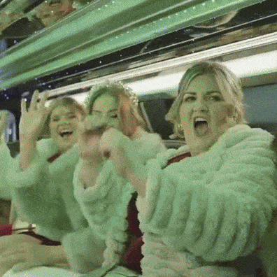 Wedding guests celebrating inside a vehicle